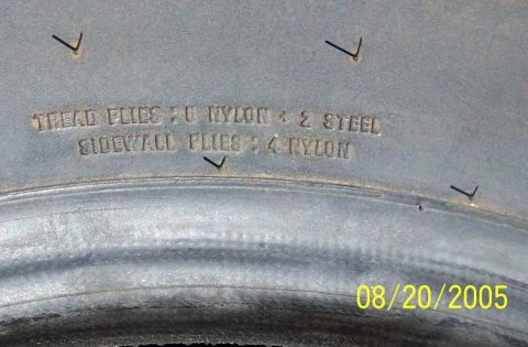 1990 Ford Bronco - tire sidewall close-up shows molded ply-rating lettering reading tread and sidewall plies, dated August 20, 2005.
