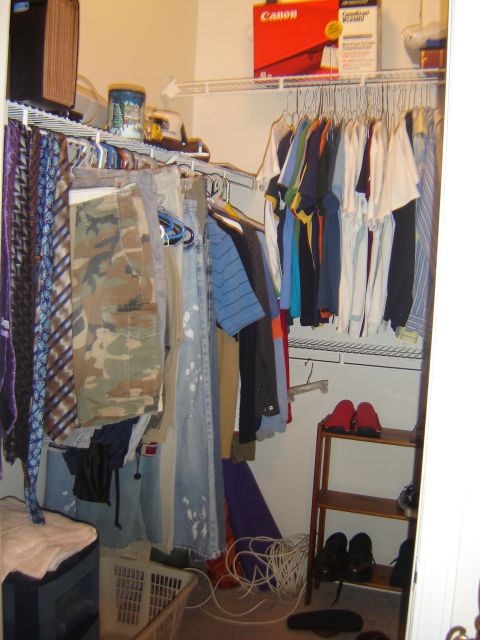 1988 Ford LTD Crown Victoria - A view inside a closet showing various clothing items, ties, camouflage pants, and a Canon box on a shelf.