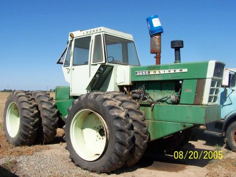 1990 Ford Bronco - green and white Oliver 2655 articulated four-wheel-drive tractor with dual wheels sits in a dirt field, dated August 20, 2005.