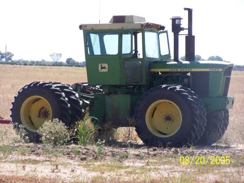 1990 Ford Bronco - green John Deere 7520 four-wheel-drive tractor with yellow-rim dual wheels stands in a dry field, dated August 20, 2005.