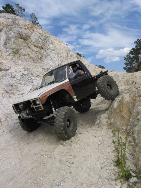 1981 Ford Bronco - This heavily modified pickup truck navigates a challenging off-road course on a steep, rocky slope.