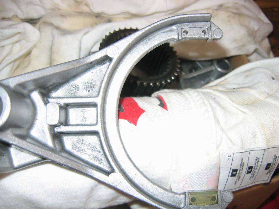 Cast aluminum clutch fork with casting numbers on white cloth
