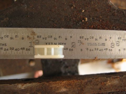 1992 Ford Bronco - A steel ruler (marked 'MADE IN U.S.A.' by Products Engineering Corp., L.A.) laid across a small white plastic part, resting on rough weathe…