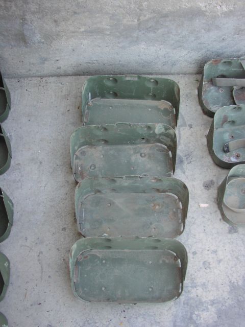 1979 Ford Bronco - Several olive drab metal containers are stacked on a concrete surface, showing signs of age and use.