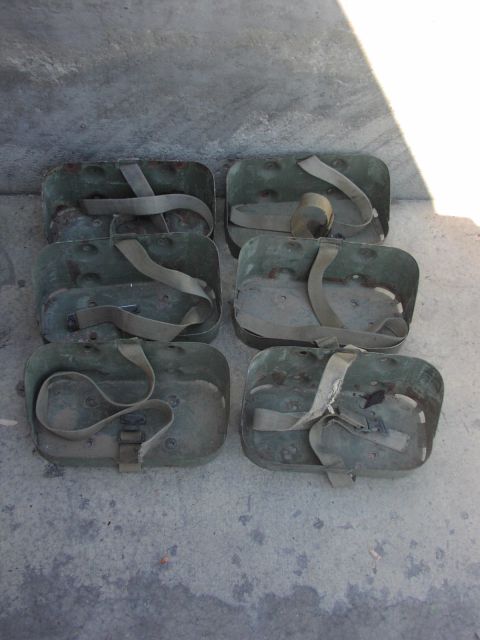 1979 Ford Bronco - Six green ammo cans with straps are arranged on a concrete surface.