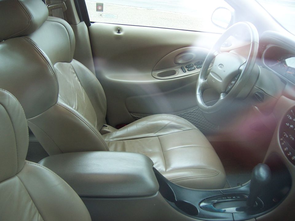 Tan leather interior of a 1996 Mercury Sable, showing front seats, dashboard, and steering wheel
