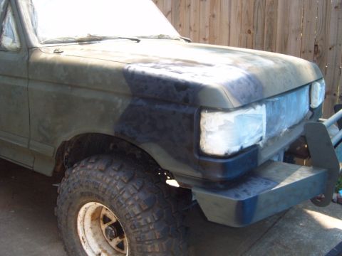1988 Ford Bronco - This Ford Bronco is undergoing a paint job with a camouflage pattern and has its headlights covered with tape.