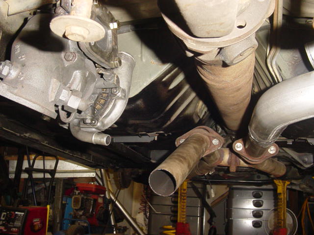 Underside view of vehicle drivetrain with transmission, driveshaft, and exhaust pipes visible