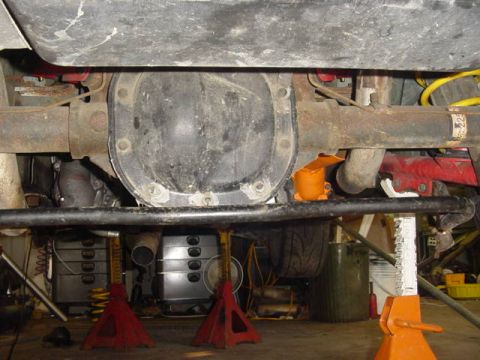 1995 Ford Mustang - Underside view of a vehicle's rear axle differential assembly supported by jack stands in a garage.