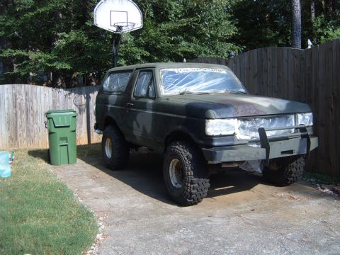 1988 Ford Bronco - A camouflaged Ford Bronco sits in a driveway next to a trash can and a basketball hoop.