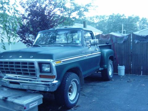 1987 Suzuki Samurai - This dark green Ford pickup truck is shown from the front 3/4 angle, with visible "FORD" badging on the grille.