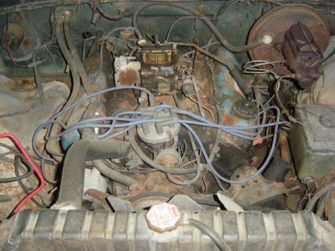 1987 Suzuki Samurai - Close-up view of a vehicle's engine bay, showing the carburetor, distributor, and radiator. No specific year or model is identifiable from…