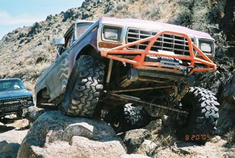 1979 Ford Bronco - Off-road modified 1978 Ford Bronco navigating rocky terrain with another vehicle in the background.