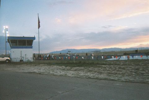 1972 Ford Ranchero - A drag strip scene unfolds at dusk, a control tower and a distant mountain range under a cloudy sky.