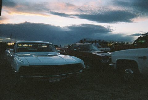 1972 Ford Ranchero - Three vehicles are parked in a grassy area under a cloudy sky at dusk.