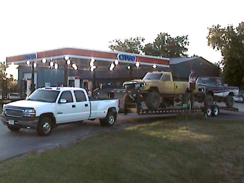 1977 Ford F-150 - Three pickup trucks are visible at a Citgo gas station, with two trucks loaded onto a trailer.