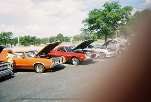 1972 Ford Ranchero - Several cars are parked in a lot with their hoods open, suggesting a car show event.
