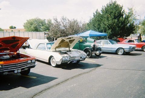 1972 Ford Ranchero - A white 1961 Ford Thunderbird convertible is displayed with its hood open at a car show, alongside other vehicles.