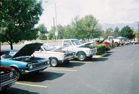 1972 Ford Ranchero - Cars parked in a lot with hoods open, likely at a car show.