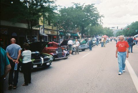 1972 Ford Ranchero - A street fair displays several classic cars, with people milling about.
