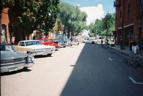 1972 Ford Ranchero - Several classic cars are parked along a street during a car show.