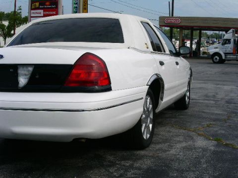 2001 Ford Crown Victoria - Rear view of a white 2001 Ford Crown Victoria parked near a Conoco gas station.