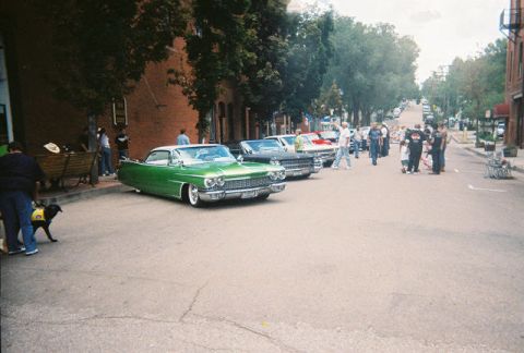 1972 Ford Ranchero - A line of classic cars are parked on a street during a car show.