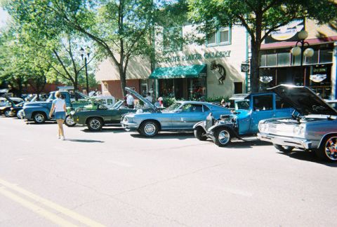 1972 Ford Ranchero - A line of classic cars are parked on a street, with their hoods open for display.