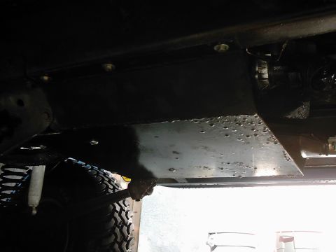 1978 Ford Bronco - Close-up view of a vehicle's underbody skid plate and suspension components.