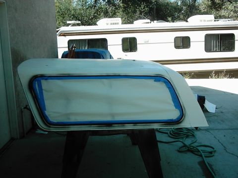1978 Ford Bronco - A car door is prepped for painting, with masking tape outlining the window area.