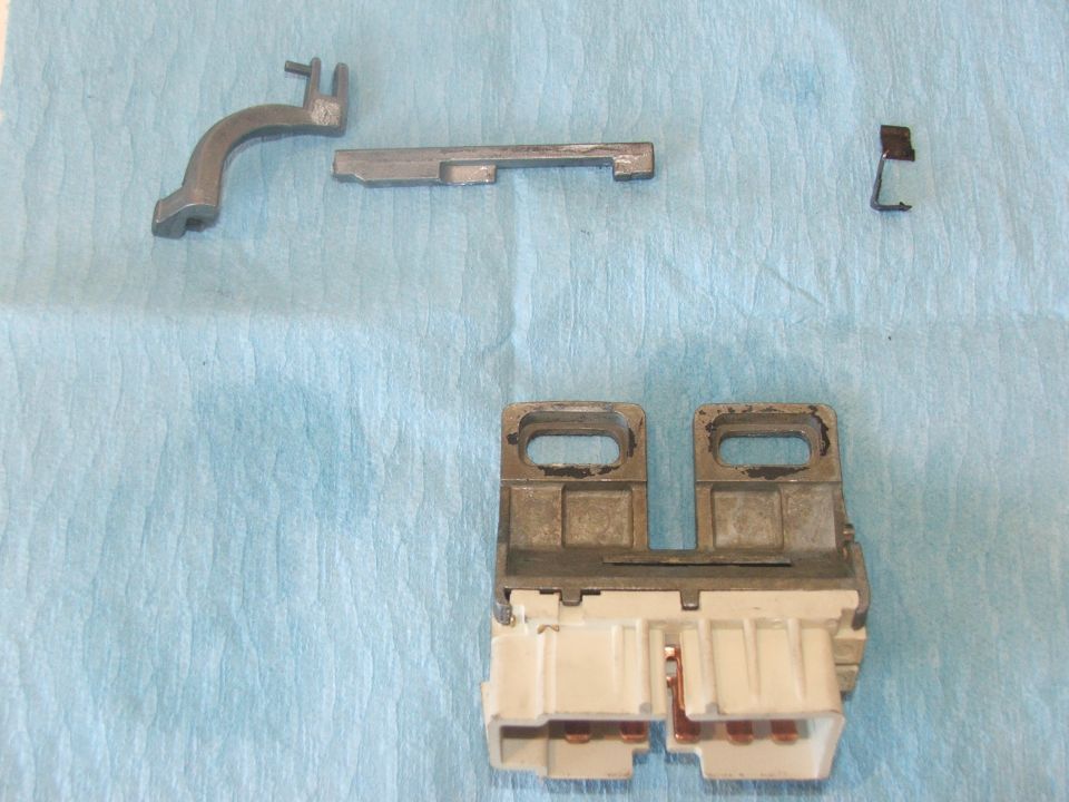 Disassembled ignition switch components on a blue cloth