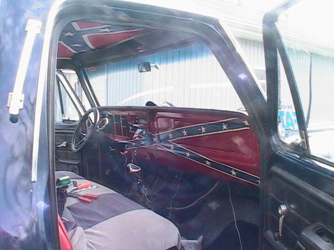 1977 Ford F-250 - The interior of a truck is decorated with confederate flag decals on the dashboard and headliner.