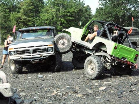 1995 Ford Bronco - A 1977 Ford F-Series truck's front end is visible as a green off-road vehicle is positioned on top of it.
