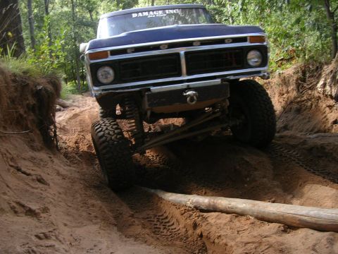 1977 Ford F-150 - This lifted Ford truck navigates a challenging off-road course, with its front grille clearly visible.