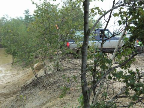 1995 Ford Bronco - This 1995 Ford Bronco is captured in a three-quarter front view as it navigates a muddy, wooded area.