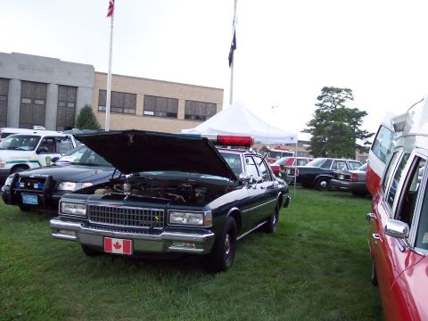 2001 Ford Crown Victoria - Police car with hood open at an outdoor car show.