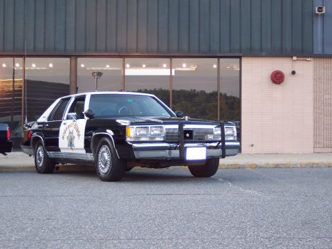 2001 Ford Crown Victoria - This police car appears to be from the 1980s, not a 2001 model, based on its body style and grille.