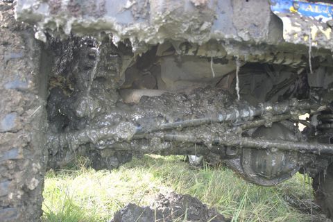2003 Jeep TJ - Undercarriage of a vehicle heavily coated in mud, obscuring most details.