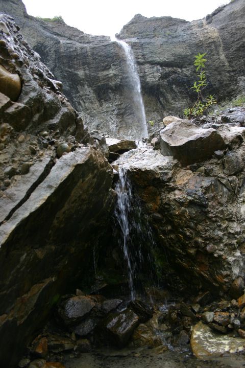 2003 Jeep TJ - A waterfall cascades over a steep, rocky incline, with water pooling at the bottom.