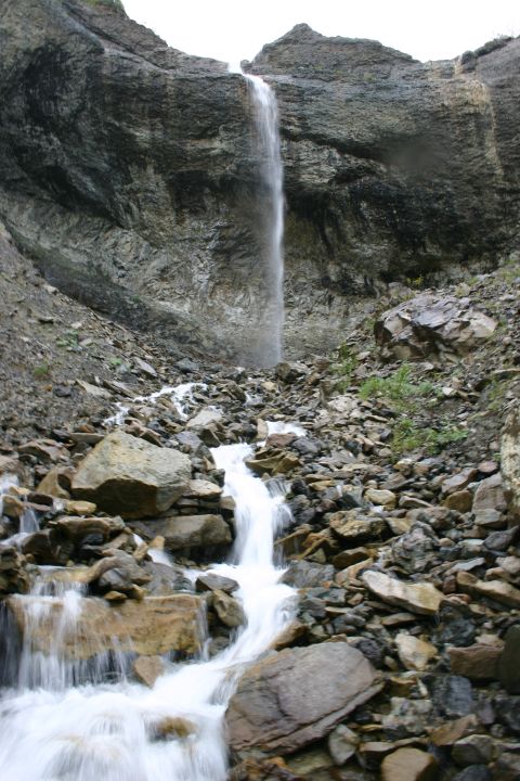 2003 Jeep TJ - A tall waterfall flows over a steep, rocky mountainside, creating a stream below.