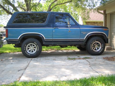 1982 Ford Bronco - Side view of a 1982 Ford Bronco parked on a concrete driveway.