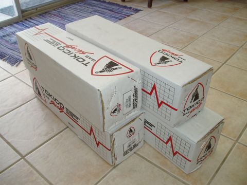 1993 Ford Taurus - Four boxes of Tokico gas shocks are stacked on a tiled floor, with a rug visible in the background.