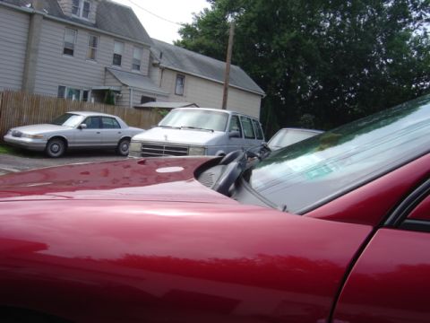 1998 Ford Taurus - Foreground shows part of a red car; background has a silver sedan and minivan.