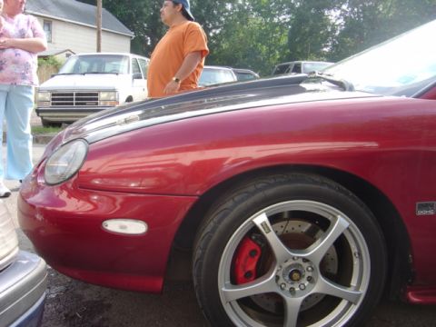 1998 Ford Taurus - Front view of a red 1998 Ford Taurus with custom wheels and a carbon fiber hood.