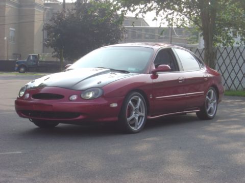 1998 Ford Taurus - This 1998 Ford Taurus has a custom black hood and aftermarket wheels.
