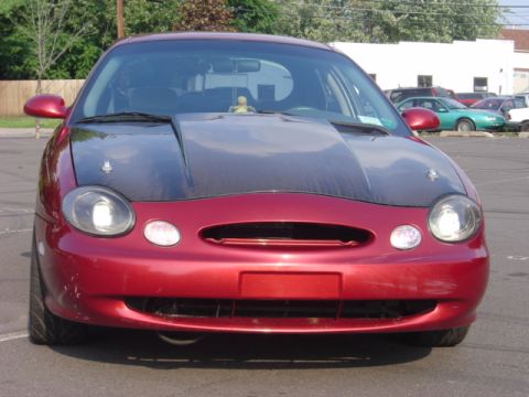 1998 Ford Taurus - Front view of a red 1998 Ford Taurus with a black hood.