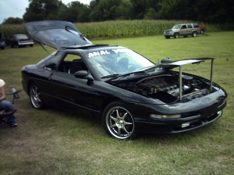 1995 Ford Probe - A black 1995 Ford Probe is parked on grass with its hood and trunk open, revealing the engine and interior.
