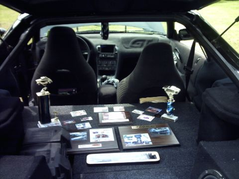 1995 Ford Probe - Trophies and plaques are displayed inside a car's interior, with the dashboard and seats visible.