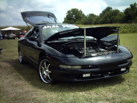 1995 Ford Probe - A black 1995 Ford Probe is displayed with its hood and trunk open, revealing the engine and cargo space.