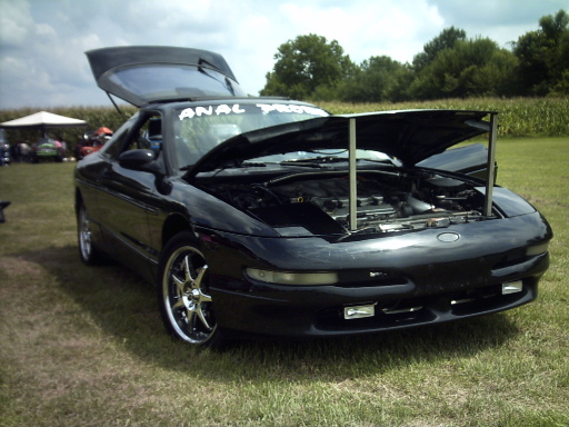 Black 1995 Ford Probe with hood and trunk open, parked on grass